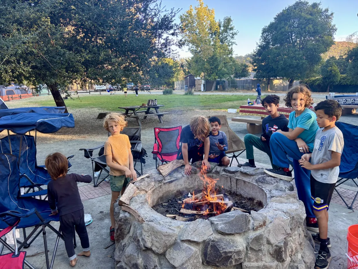 Pack 212 Scouts spending time together around a campfire during a campout